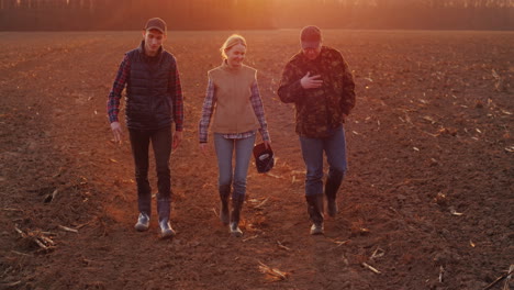 a successful family of farmers goes on a plowed field 4k video