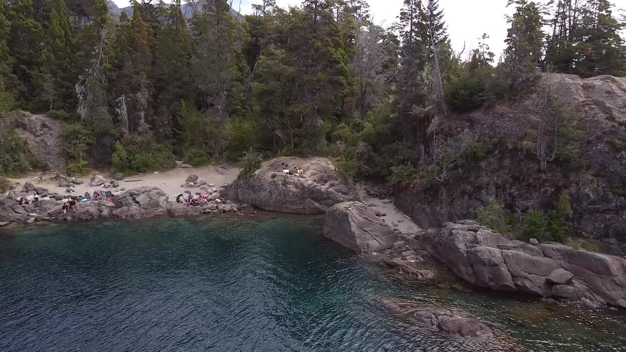 lago de agua azul nahuel huapi rodeado de bosque de pinos con costa rocosa en la patagonia argentina