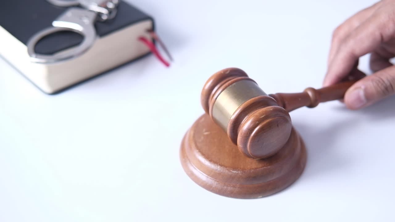 martillo y esposas en una mesa