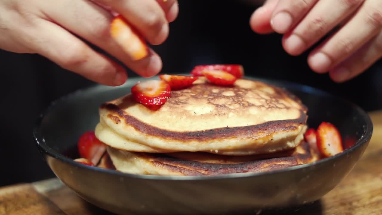 dropping fruit on thick pancake stack