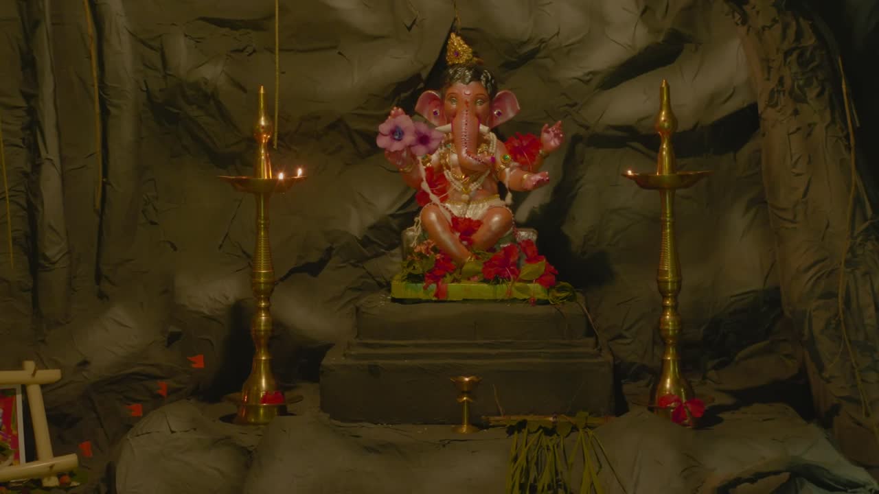 Statue of Ganesha with lamps and flowers, creating a spiritual vibe