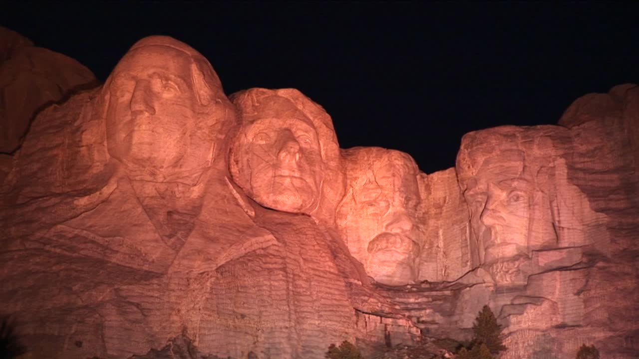 El Monte Rushmore Está Bañado en Luz Cálida por la Noche