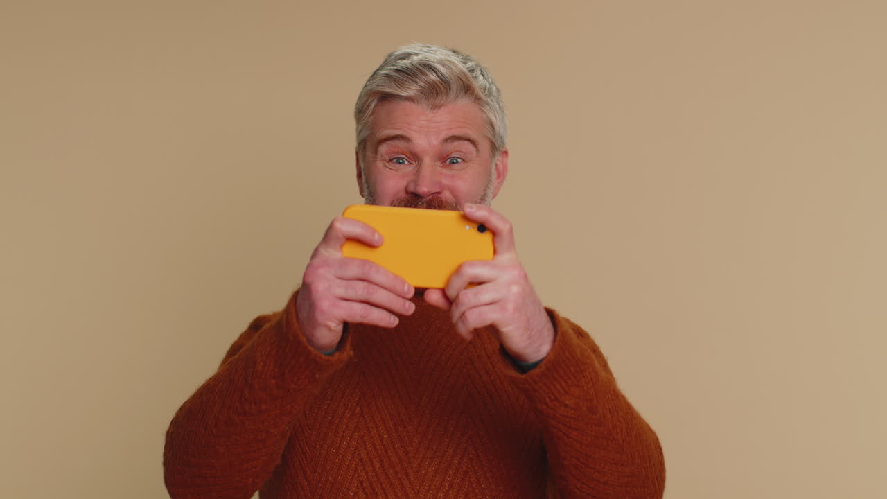 걱정스러운 재 ⁇ 는 중독된 관광객이 휴대폰에서 드라이브 레이싱 비디오 게임을 열정적으로 즐기고 있습니다.