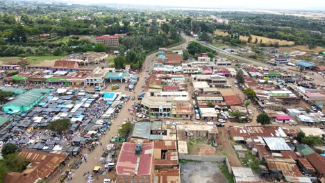 aerial view of cars and people at a open air market, in africa - reverse, drone shot