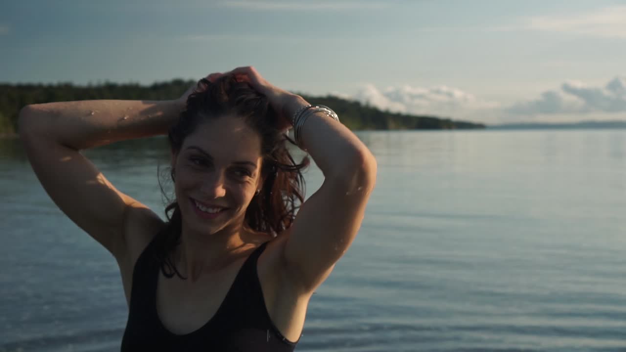 cara sonriente de mujer caucásica, emociones reales honestas, cabello mojado, fondo de playa