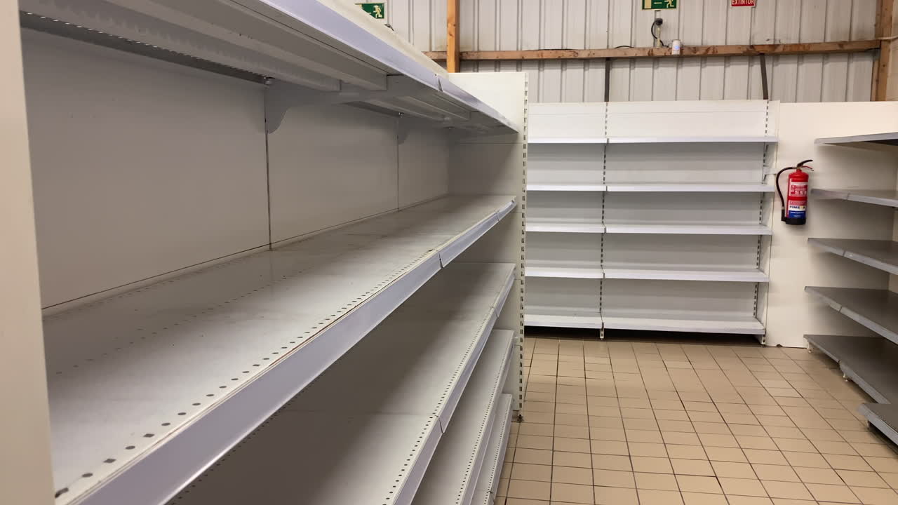 Concetto di fallimento: Scaffali vuoti del supermercato, negozio in chiusura