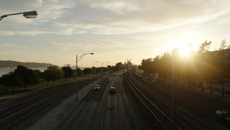 cars driving through the highway at dusk with dazzling sun in lisbon, portugal. - handheld shot