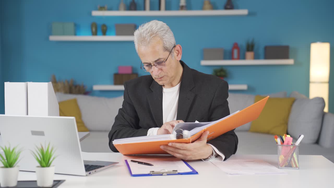 trabajador de oficina en casa revisando archivos de papeleo.