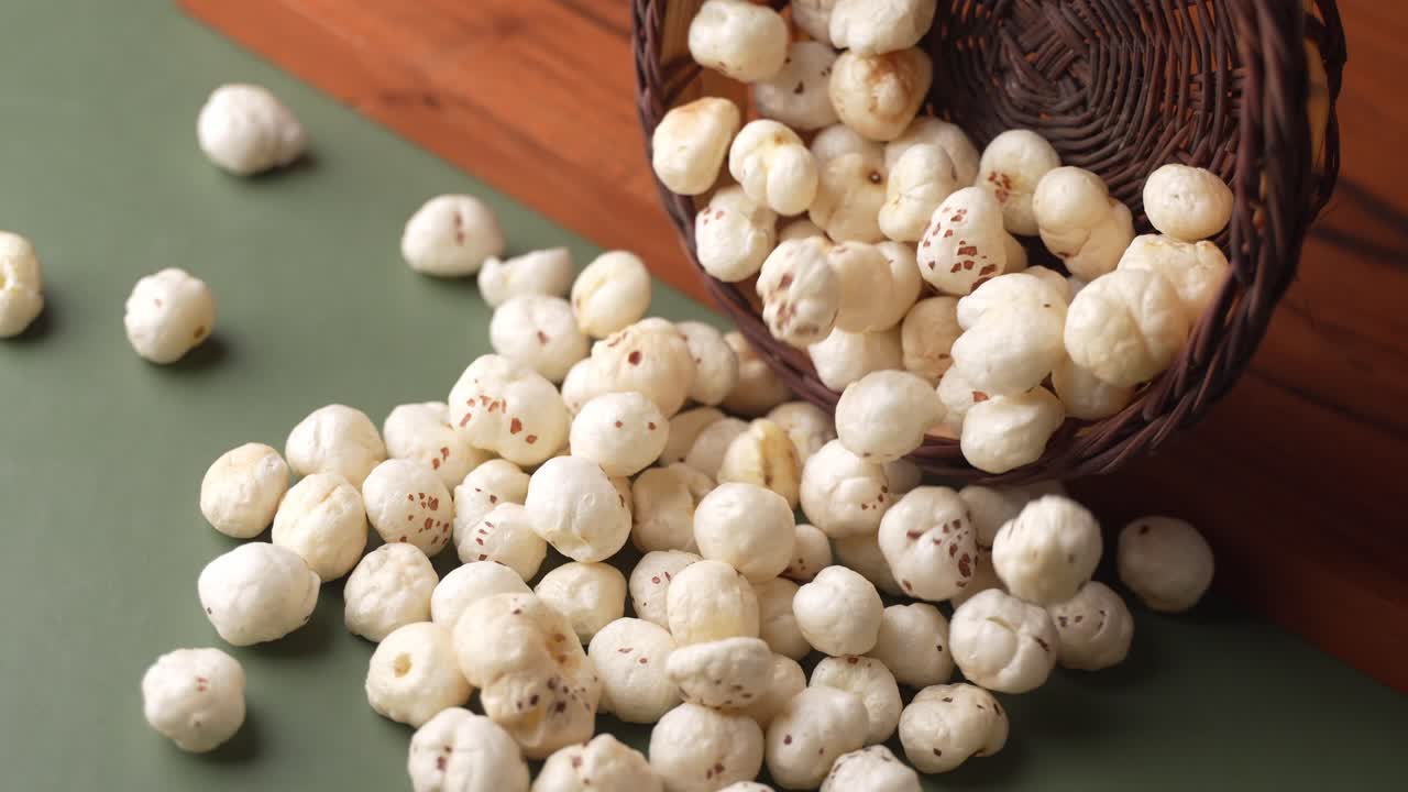Primo piano di makhana che cade da una ciotola di legno