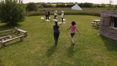 drone shot of teacher leading group of mature men and women in class at outdoor yoga retreat