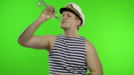 sailor man walking, drinks vodka from bottle. seaman guy in sailor's vest.