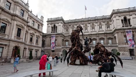 people observing a large outdoor sculpture