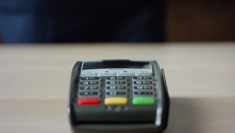 hands making contactless payment with credit card at machine terminal close up.