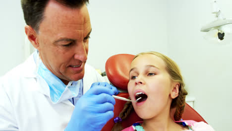 Dentist-examining-a-young-patient-with-tools