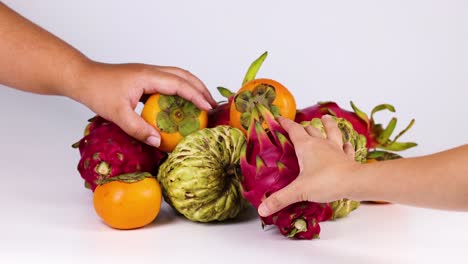 manos seleccionando y retirando frutas de una pila