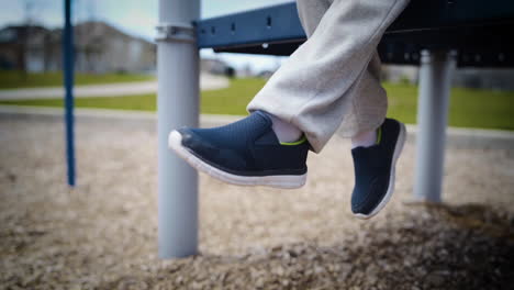 Cute-boy-dangling-his-feet-in-a-park-in-slow-motion