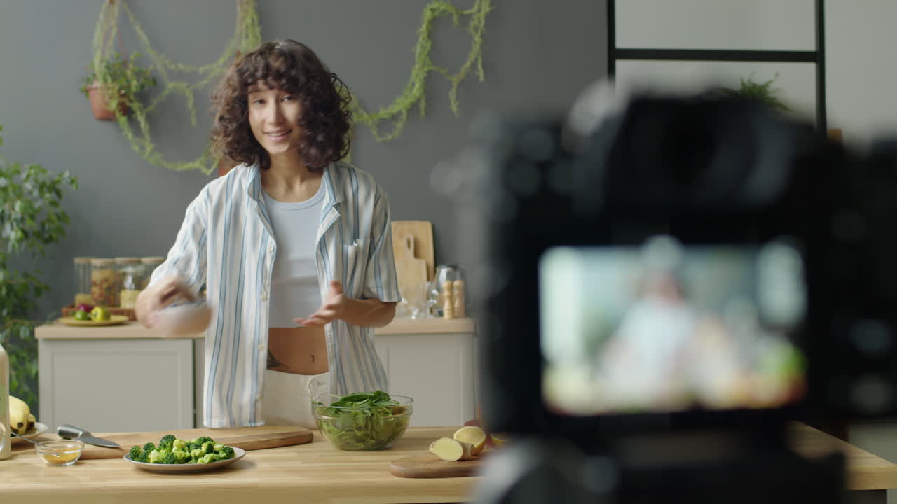 Female Blogger Filming Smoothie Recipe in Kitchen