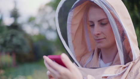 the beekeeper uses a smartphone while working