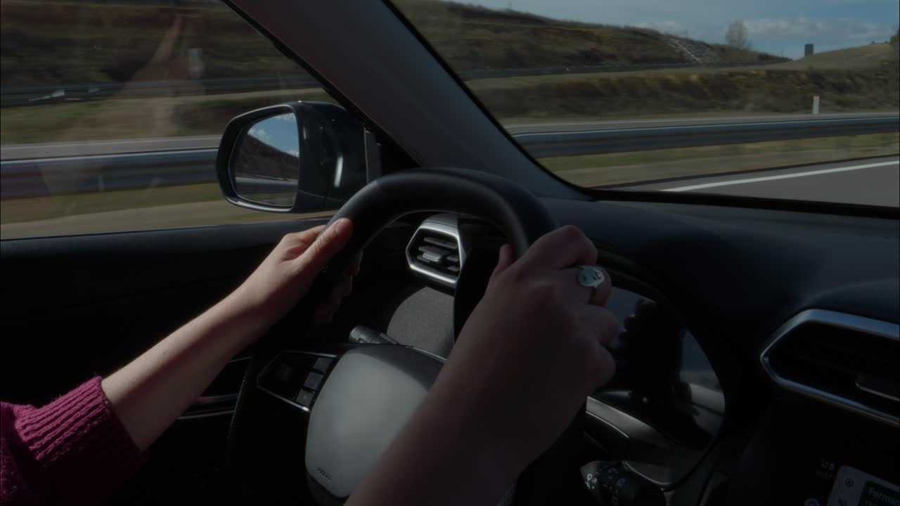 Hænder på rat under bilkørsel på motorvej i dagtimerne