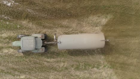 tractor with a trailer spreading fertilizer aerial view