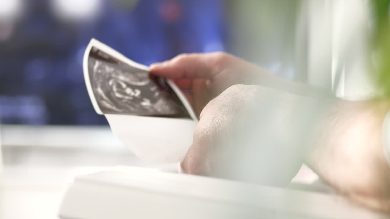 Male Hands Holding Ultrasonographic Picture, Fatherhood, Low, Medium, Dolly