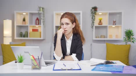 Mujer-Trabajadora-De-Oficina-En-Casa-Mordiéndose-Las-Uñas-Mirando-A-La-Cámara.