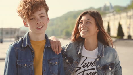 a young teenage couple jokes and looks funny straight into the camera