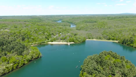 aerial of a beautiful small beach on a lake embedded in the thick forest mountains of wisconsin, usa