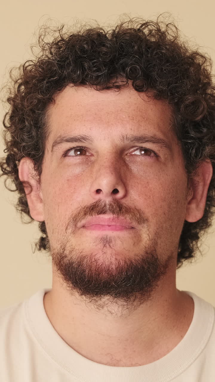 Primo piano di giovane uomo pensieroso che guarda in alto