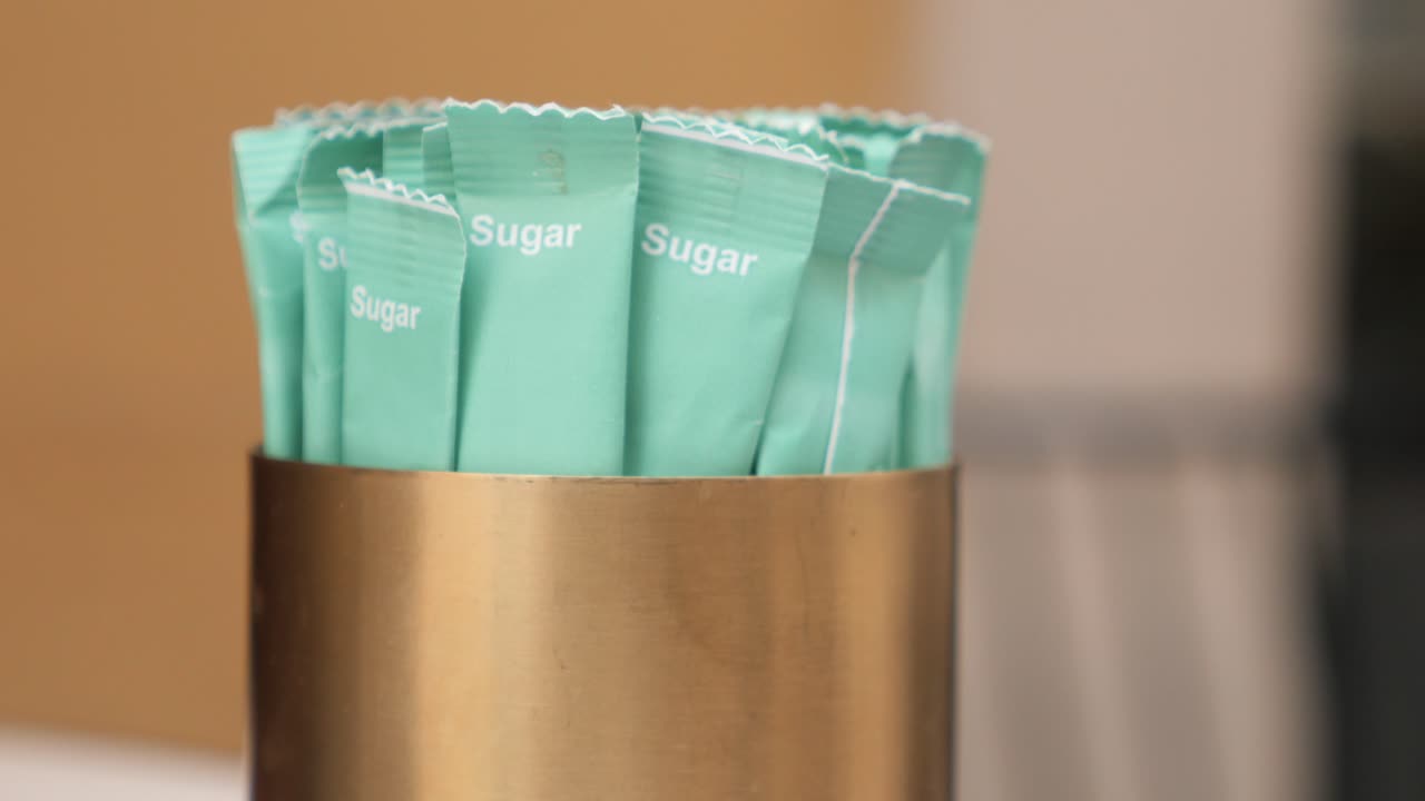 테이블 위 에 있는 설탕 패키지 들 의 컨테이너 의 근접