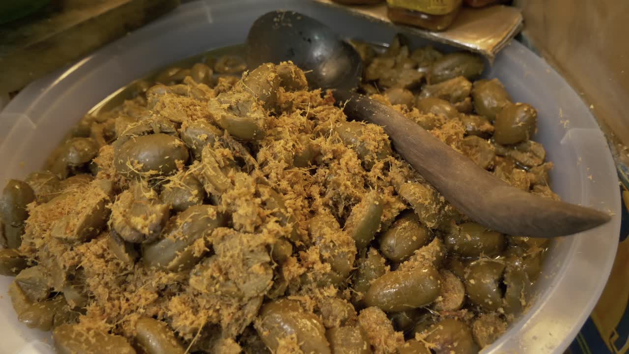 aceituna sazonada con jengibre amarillo en un puesto de venta de comida callejera asiática documental