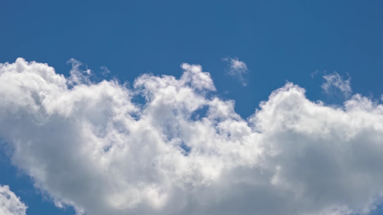 Clouds float in the blue sky during a sunny day