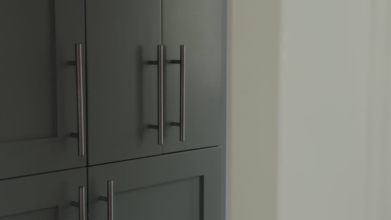 Sağdan sola kaydırma, modern bir evde metal kulplu şık dolap kapaklarını ortaya çıkarıyor.