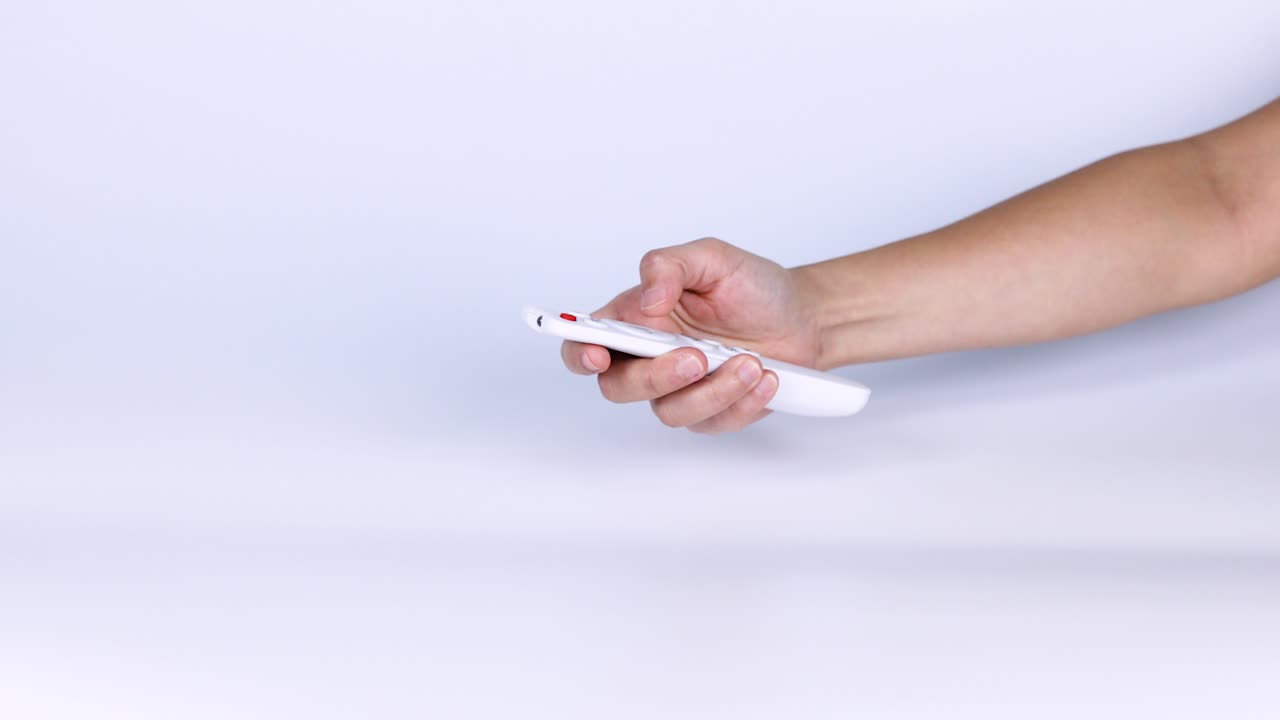 Hand pressing buttons on a remote control