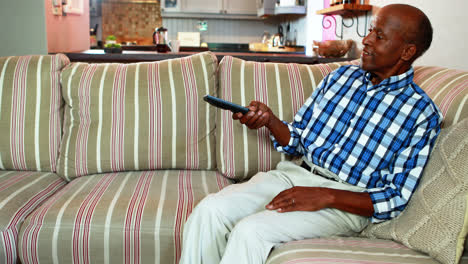 hombre mayor viendo la televisión en la sala de estar