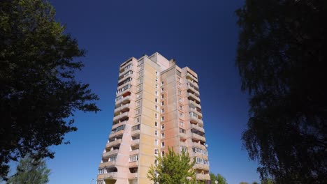 disparo fijo de un edificio de apartamentos de hormigón de gran altura con un pájaro negro pasando