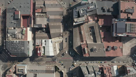 Top-down-panning-footage-of-square-blocks-of-buildings-lined-by-streets-in-city-on-sunny-day.-Barcelona,-Spain