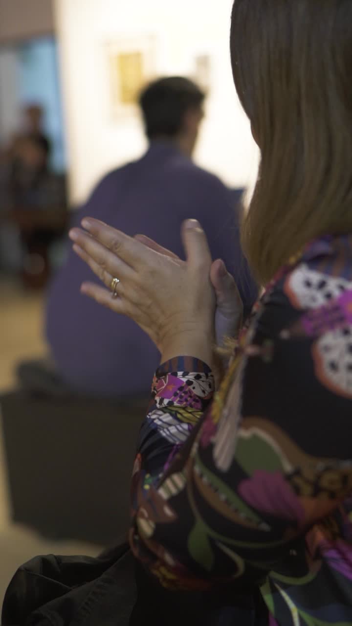 Adult woman applauds, celebrating and approving participation in a cultural event