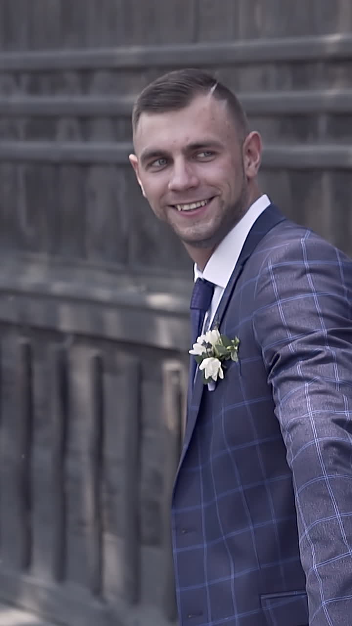 backside view bride and fiance run joining hands near brown fence on sunny day slow motion closeup