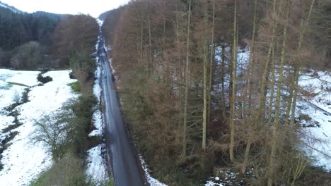 Schneebedeckter-Walisischer-Wald-Moel-Famau-Winterlandschaft-Luftbild-Absteigend-Direkt-über-Die-Landstraße