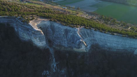 aerial view of a dramatic cliff face and surrounding landscape