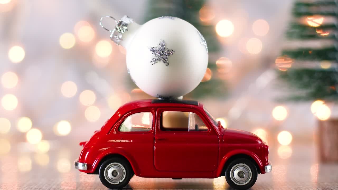 Red little car with Christmas white ornament for Christmas tree and blinking lights