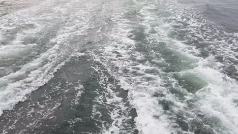 waves from a large ferry boat sailing across the ocean