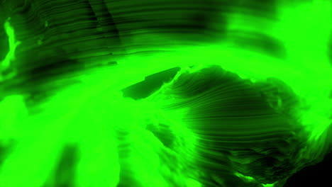 green vibrant glowing abstract shape flowing against black background