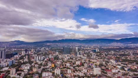 Flying-over-Mixcoac-in-Mexico-City-with-clouds-rolling-over-Ajusco-Mountains