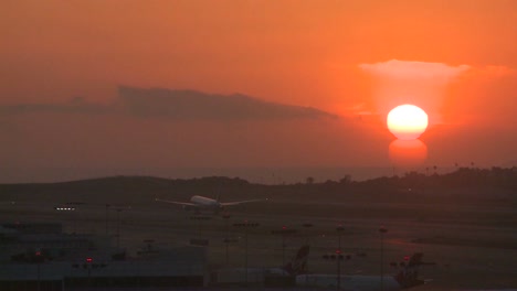 a plane takes off into the sunset or sunrise