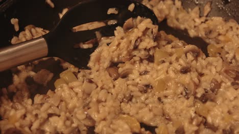 una sartén lenta de risotto de hongos de castaño que se está cocinando