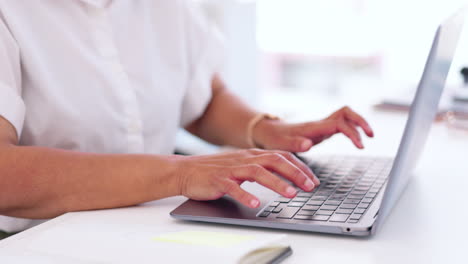 mujer de negocios, manos y computadora portátil escribiendo en la oficina