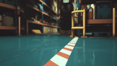 warehouse interior with colorful flooring and stored items visible on shelves