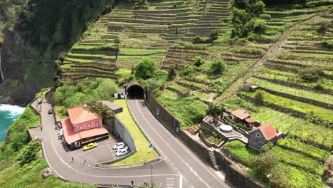 Vista-Aérea-De-La-Ladera-Del-Viñedo-Costero-En-Terrazas-De-Seixal-Hacia-La-Entrada-Del-Túnel-De-La-Carretera-De-Montaña-De-João-Delgado